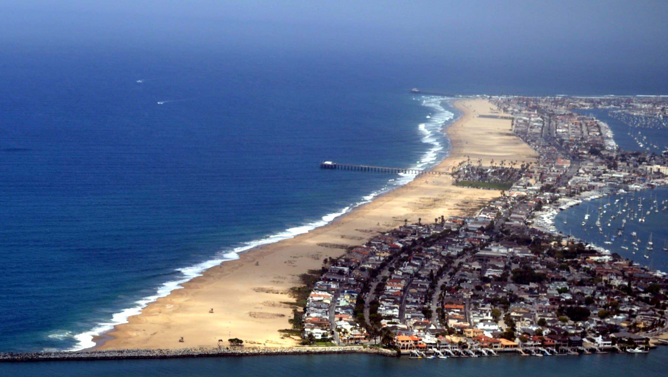 The eastern end of the Balboa Peninsula in Newport Beach from the air in May 2010, with the ocean beach and Balboa Pier at left and bayfront homes and docks along Newport Harbor at right (file photo)