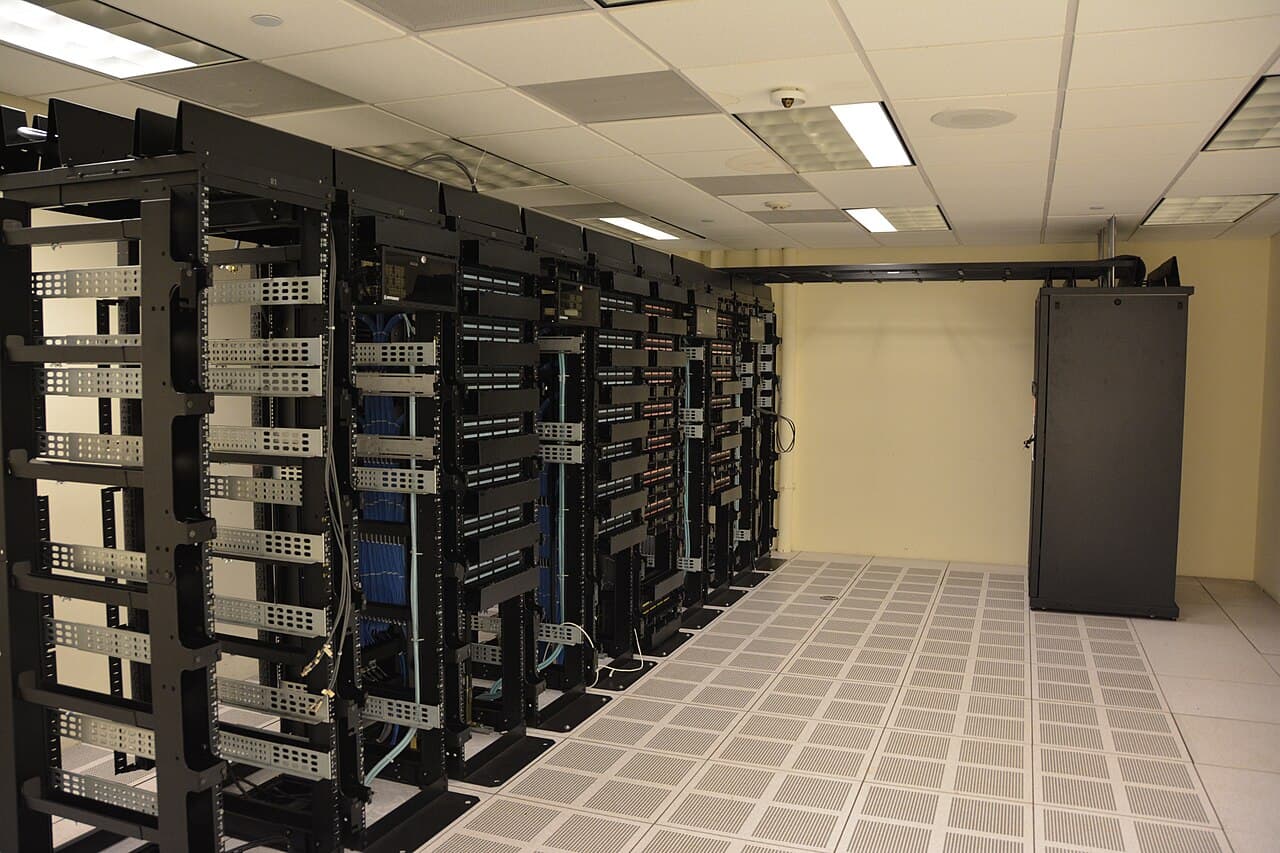 Rows of equipment racks running the length of an empty data centre hall