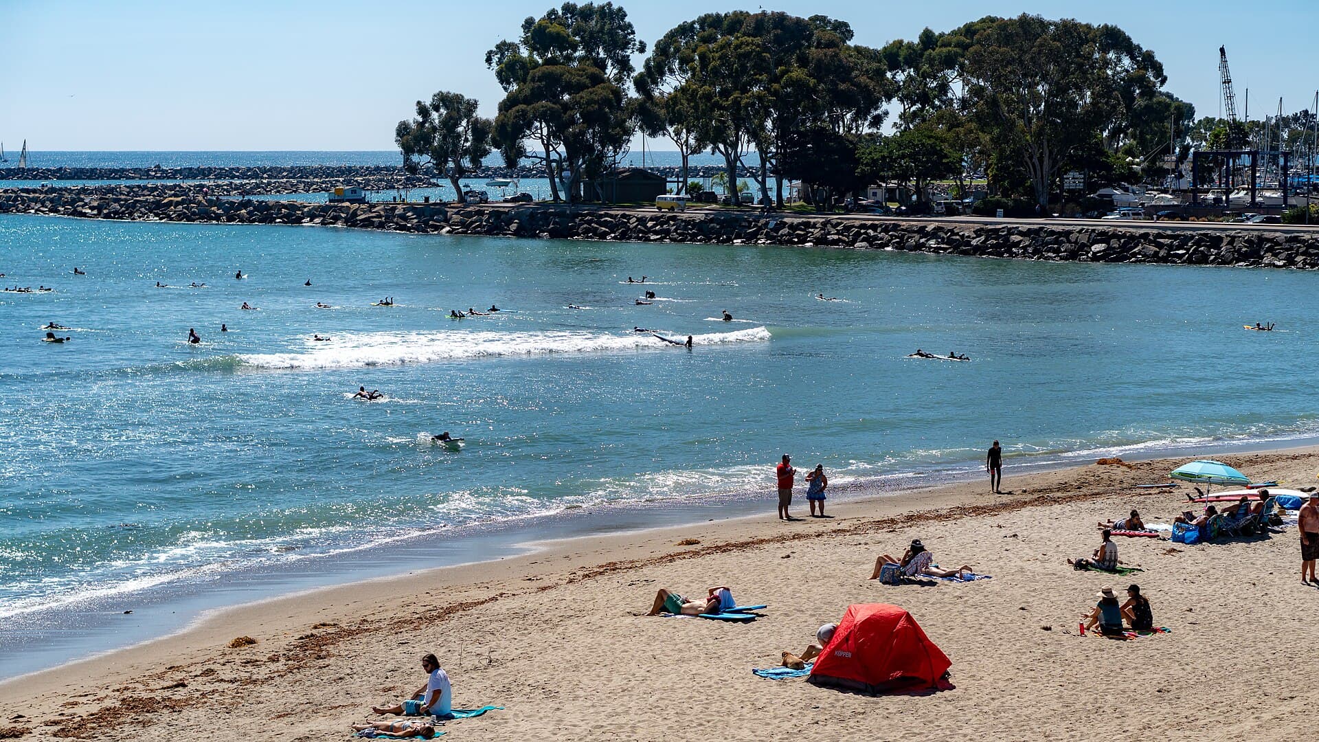 Surfers and beachgoers at Doheny State Beach in Dana Point, with the Dana Point Harbor breakwater behind, photographed Sept. 29, 2018 (file photo)
