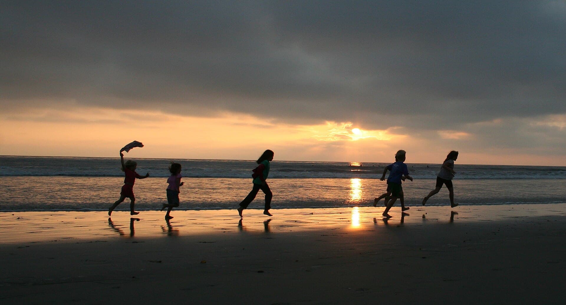 Children run along the water's edge at sunset at San Elijo State Beach in Cardiff, San Diego County, Aug. 23, 2008 (file photo; not program participants)