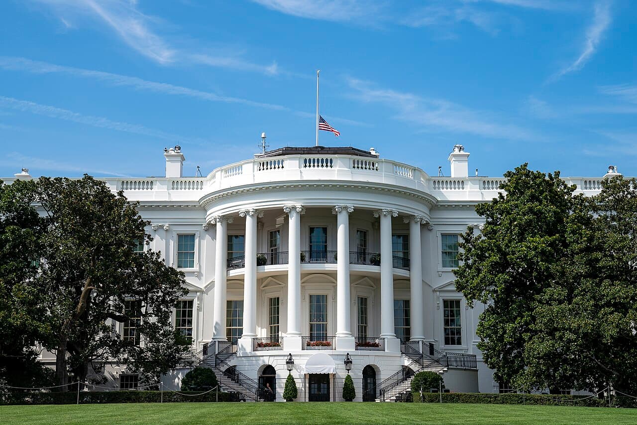 The United States flag flying at half-staff above the White House