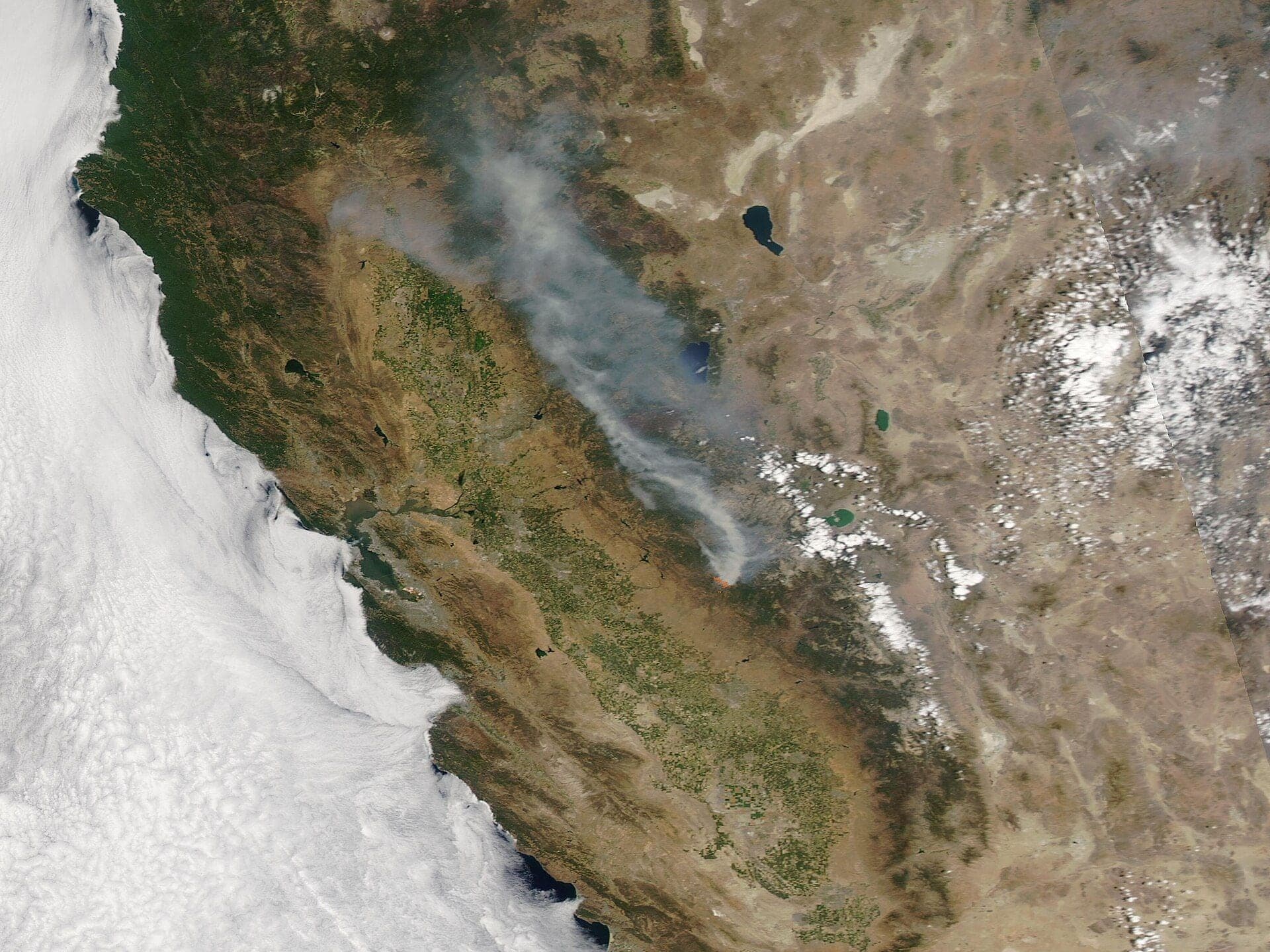 A satellite view of northern California with the smoke plume and hotspot of the Oak Fire in Mariposa County drifting north-east across the Sierra