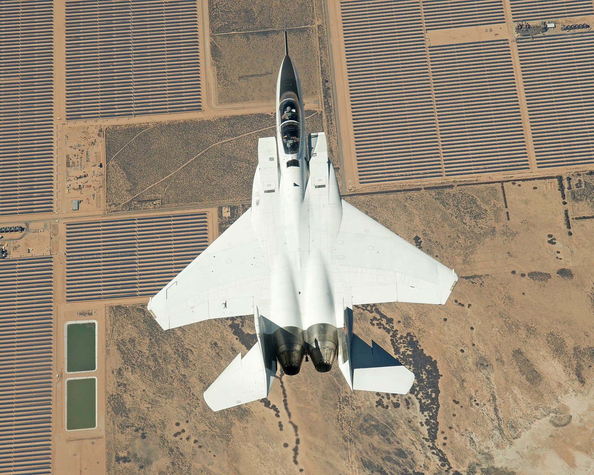 A NASA Armstrong F-15B over the Mojave Solar Project near Highway 58, photographed March 10, 2016, from an F-15D flown inverted by NASA research pilot Troy Asher (NASA file photo)