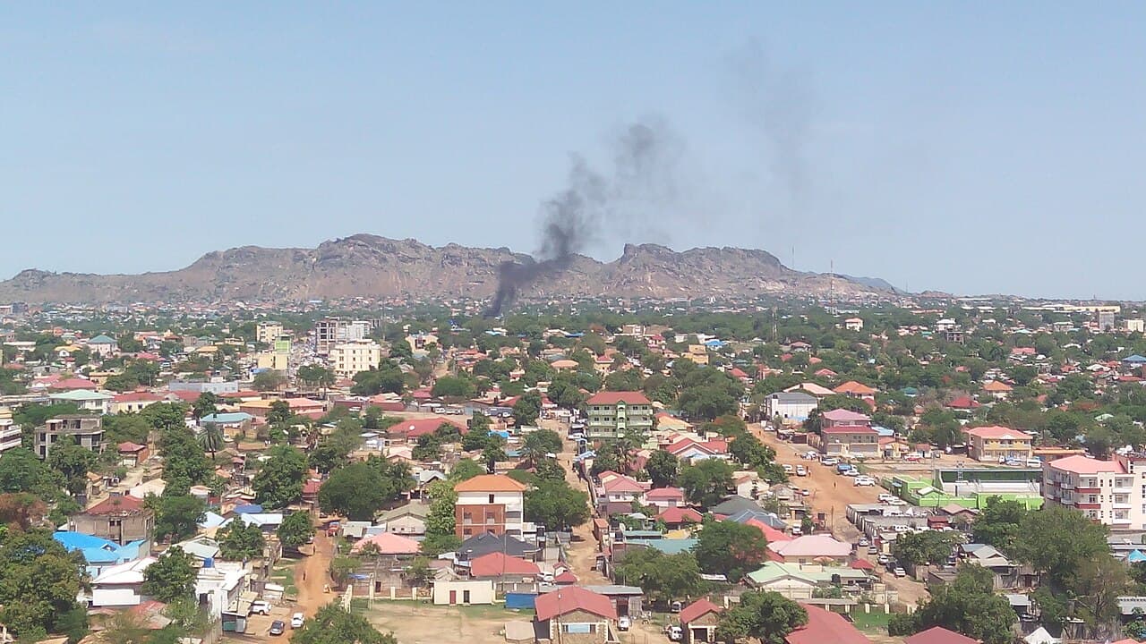 A view across Juba, South Sudan, with smoke rising beyond the rooftops